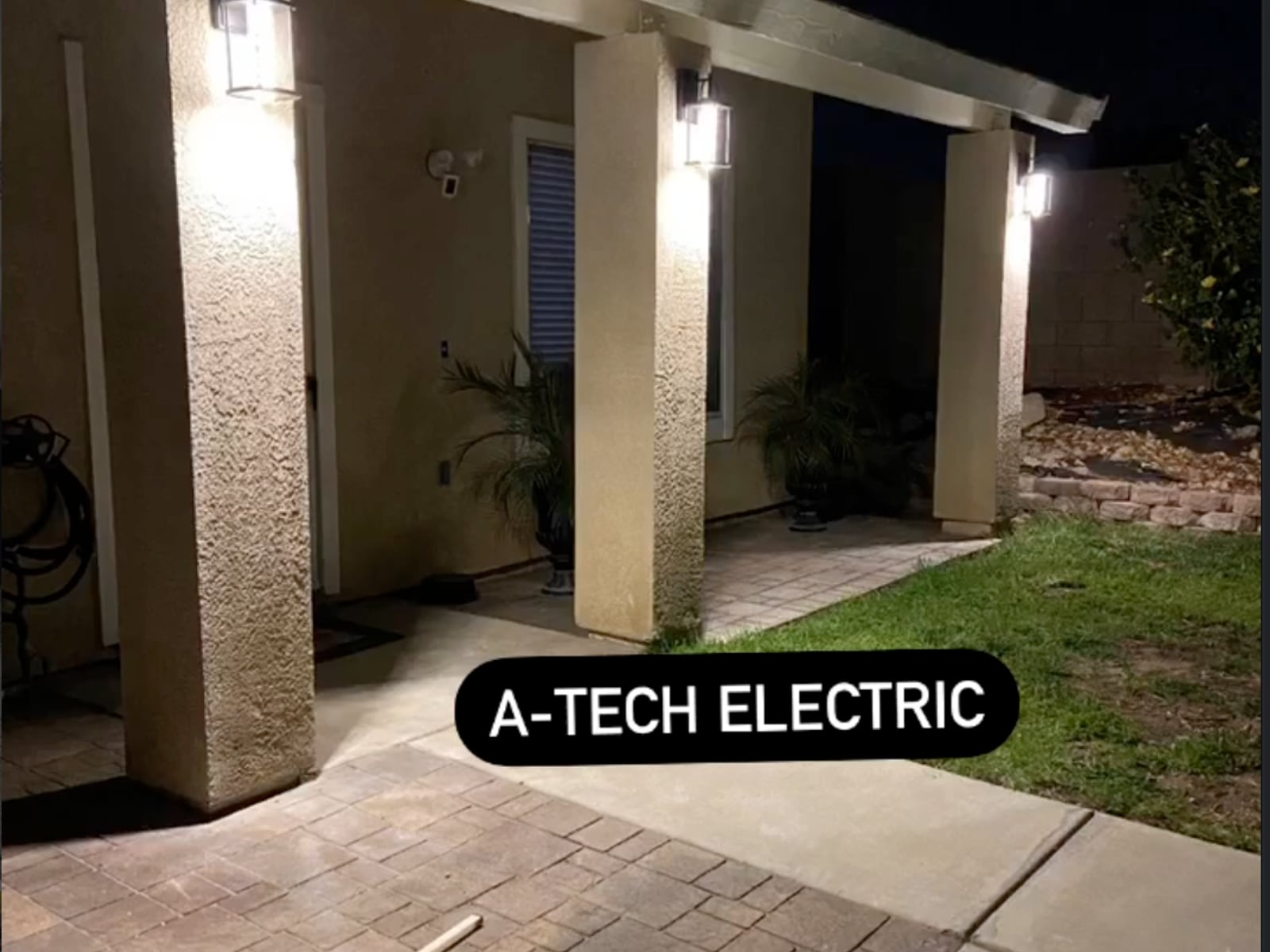 Three illuminated exterior wall lights installed by A-Tech Electric on a covered residential patio in Orange County, California.