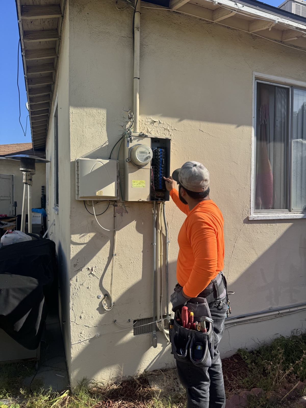 A-Tech electrician removing an aging 100-amp electrical panel and meter on a Moreno Valley, CA home before the upgrade.