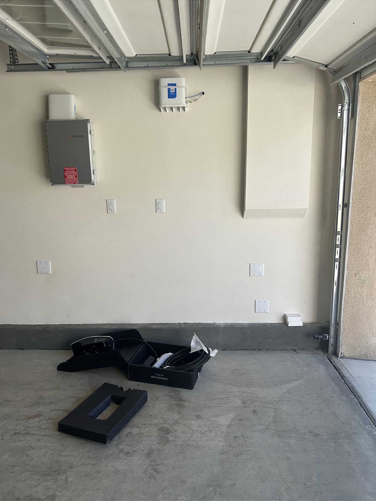 Tesla Wall Connector and charging cable before installation in a residential garage in Fontana, California.